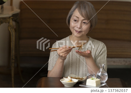 リビングで晩酌をするシニア女性 137362037