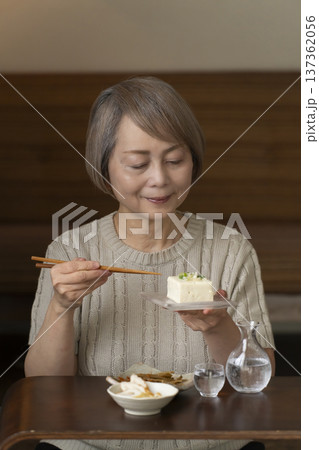 リビングで晩酌をするシニア女性 リビングで晩酌をするシニア女性 137362056