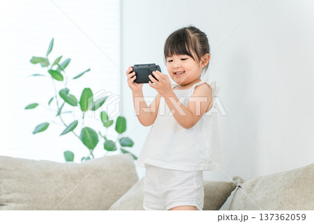家でゲームに夢中になる笑顔の子供,女の子 家でゲームに夢中になる笑顔の子供,女の子 137362059