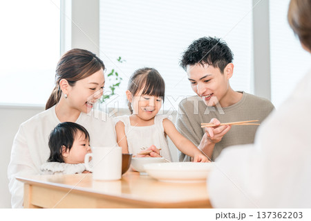食卓でおままごとをしながらお箸の練習をする女の子と家族,ファミリー 食卓でおままごとをしながらお箸の練習をする女の子と家族,ファミリー 137362203