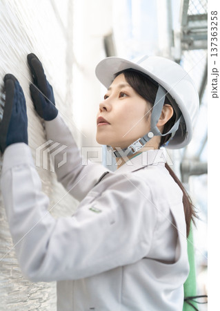 住宅の点検・メンテナンスを行う女性の建築技術者 住宅の点検・メンテナンスを行う女性の建築技術者 137363258
