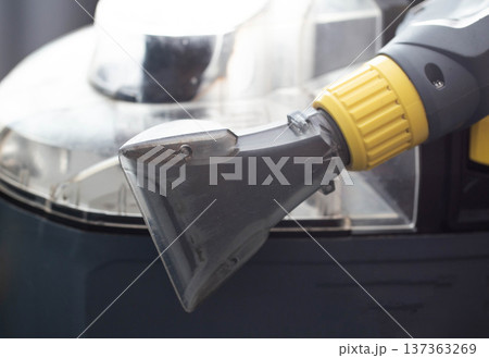 Close up view of transparent nozzle head from professional wet vacuum cleaner machine for deep cleaning of sofa and upholstery fabric. 137363269