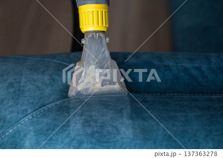 Deep cleaning of a blue upholstered sofa using a cleaning tool for dirt removal Deep cleaning of a blue upholstered sofa using a cleaning tool for dirt removal 137363278