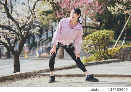 屋外でストレッチをする女性 ランニング前後の準備運動 健康的な運動習慣 屋外でストレッチをする女性 ランニング前後の準備運動 健康的な運動習慣 137363449