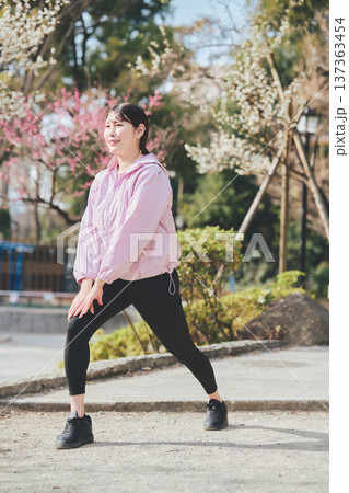 屋外でストレッチをする女性 ランニング前後の準備運動 健康的な運動習慣 137363454