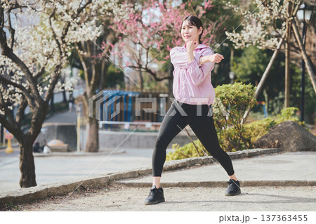 屋外でストレッチをする女性 ランニング前後の準備運動 健康的な運動習慣 屋外でストレッチをする女性 ランニング前後の準備運動 健康的な運動習慣 137363455