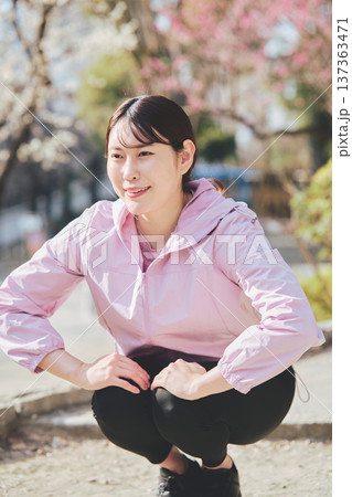 屋外でストレッチをする女性 ランニング前後の準備運動 健康的な運動習慣 屋外でストレッチをする女性 ランニング前後の準備運動 健康的な運動習慣 137363471