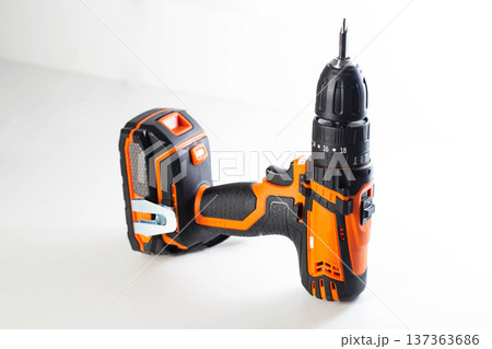 Cordless drill with screwdriver bit on white background power tool for construction home improvement and DIY projects with bright orange and black casing showcasing modern design and portability Cordless drill with screwdriver bit on white background power tool for construction home improvement and DIY projects with bright orange and black casing showcasing modern design and portability 137363686