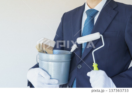 ペイントローラーと刷毛の入ったバケツを持つビジネスマン｜リフォーム・塗装業者・DIY　イメージ 137363733