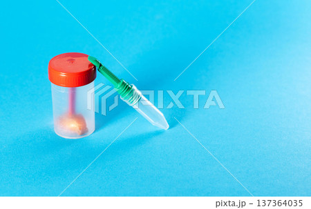 A medical test tube containing a stool sample for larvae, helminth eggs, and protozoa. Stool analysis and Helicobacter pylori testing. Copy space for text. Bowel diseases 137364035