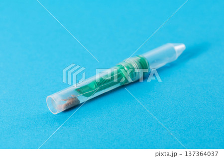A stool sample tube on a blue background. Conceptual study of biomaterial for dysbiosis and pancreatic elastase. Copy space for text A stool sample tube on a blue background. Conceptual study of biomaterial for dysbiosis and pancreatic elastase. Copy space for text 137364037