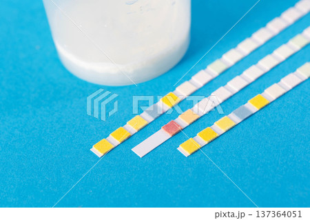Test strips next to ejaculate analysis on a blue background, concept of measuring leukocytes and microscopy of ejaculate and prostate juice using the express method, close-up Test strips next to ejaculate analysis on a blue background, concept of measuring leukocytes and microscopy of ejaculate and prostate juice using the express method, close-up 137364051