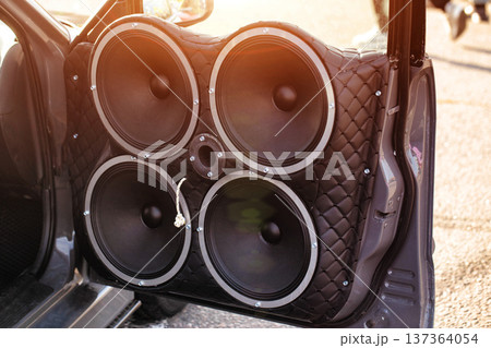 Car Door Trimmed In Quilted Leather With Four Large Speakers. Powerful Custom Auto Sound Equipment. Car Door Trimmed In Quilted Leather With Four Large Speakers. Powerful Custom Auto Sound Equipment. 137364054