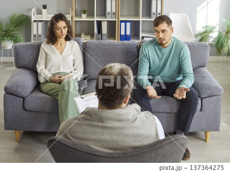 Couple meeting with doctor for discussion of diagnosis and treatment in medical clinic 137364275