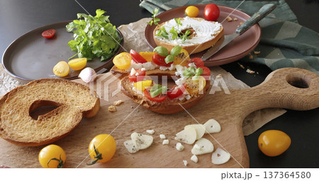 Round bruschetta with red and yellow cherry tomatoes and goat cheese on oak wooden board. Farm produce, crusty bread. Food and healthy eating. Round bruschetta with red and yellow cherry tomatoes and goat cheese on oak wooden board. Farm produce, crusty bread. Food and healthy eating. 137364580