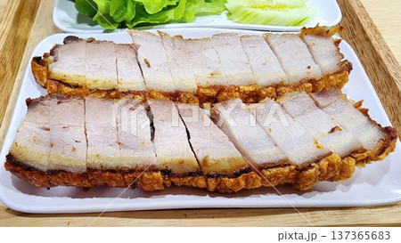 Sliced Crispy Roasted Pork Belly with Crunchy Golden Skin on a White Plate 137365683