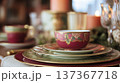 Exquisite china teacup with floral pattern and gold accent sitting on layered plates, creating a lavish table setting 137367718