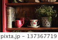 Vintage teacup with floral pattern and antique books arranged on a cozy wooden bookshelf at home 137367719