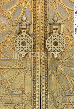 Brass doors adorned with Moroccan patterns, metal filigree, and intricate relief work. Royal Palace, Fez, Morocco Brass doors adorned with Moroccan patterns, metal filigree, and intricate relief work. Royal Palace, Fez, Morocco 137367937
