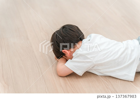 リビングのフローリングでぐずる男の子 リビングのフローリングでぐずる男の子 137367983