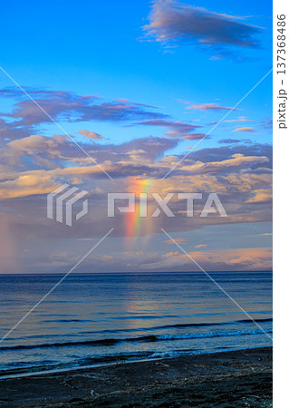 海上に降る雨と虹の光芒（ドラマチックな空の風景） 137368486