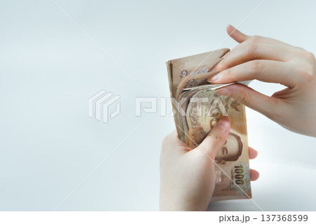 money income and invest concept with woman hand during count thai banknote on white isolated background money income and invest concept with woman hand during count thai banknote on white isolated background 137368599