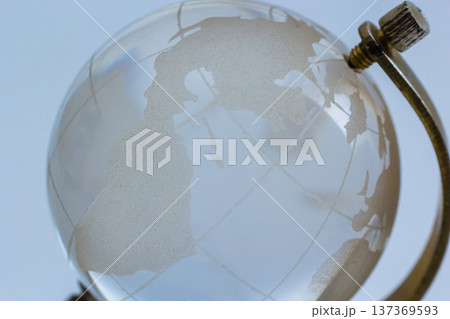 Globe highlighting continents with a vintage design resting on a simple stand in a softly lit room 137369593