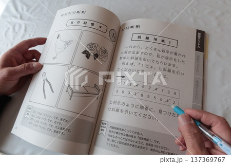 運転免許認知機能検査の対策をする高齢男性の手元とテキスト 137369767