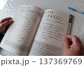 運転免許認知機能検査の対策をする高齢男性の手元とテキスト 137369769