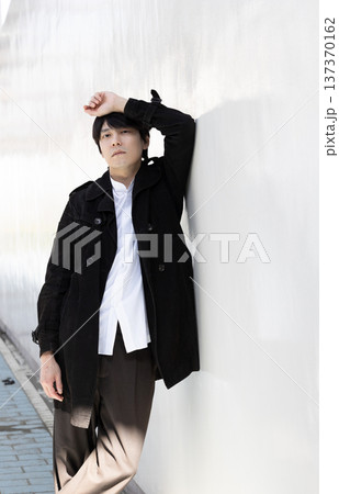 壁によりかかっている男性 137370162
