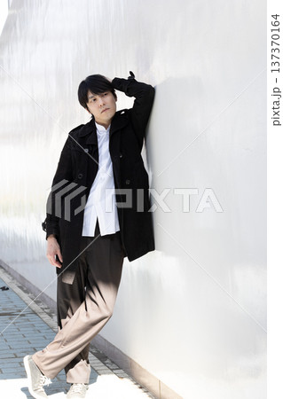 壁によりかかっている男性 137370164