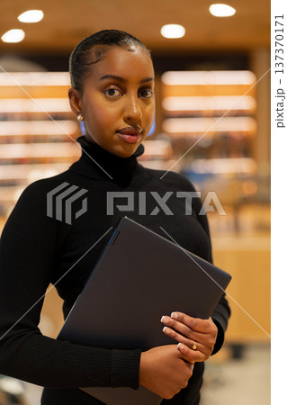 Student with laptop in library setting 137370171