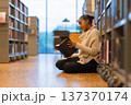 Student reading a book in library 137370174