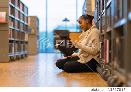 Student reading a book in library 137370174