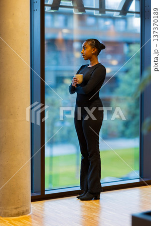 Woman looking through large window 137370189