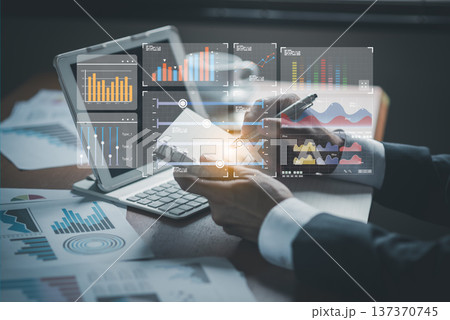 Businessman writing in notebook with pen while analyzing virtual financial bar charts and data statistics overlay Businessman writing in notebook with pen while analyzing virtual financial bar charts and data statistics overlay 137370745