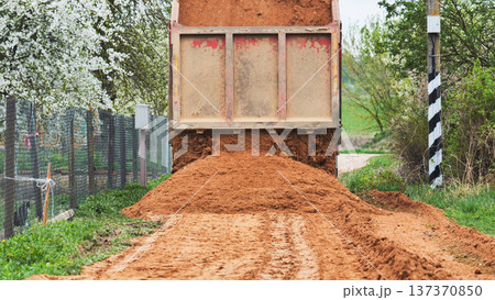 Dump truck delivering soil for earthwork, road construction, land development 137370850