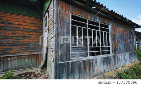 Abandoned wooden house showing rustic decay, peeling paint, and weathered siding Abandoned wooden house showing rustic decay, peeling paint, and weathered siding 137370860