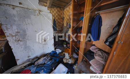 Run-down room showing poverty and neglect with messy clothes and dirty floor Run-down room showing poverty and neglect with messy clothes and dirty floor 137370883