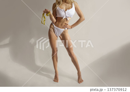 Sexy fitness diet banner with slim woman holding measuring tape in white lingerie, weight loss and healthy body concept with copy space Sexy fitness diet banner with slim woman holding measuring tape in white lingerie, weight loss and healthy body concept with copy space 137370912