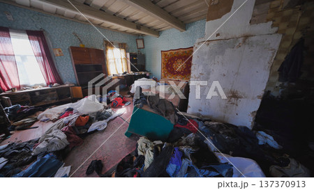 Neglected rural home interior with clothes and items scattered on floor Neglected rural home interior with clothes and items scattered on floor 137370913