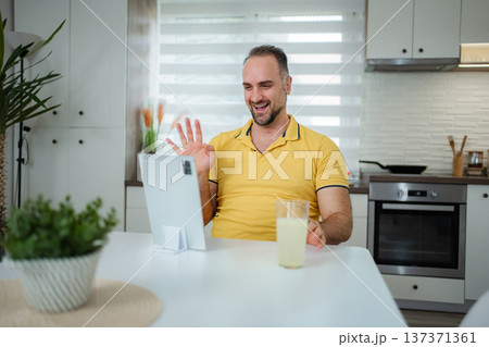 Man making video call with tablet in modern kitchen 137371361