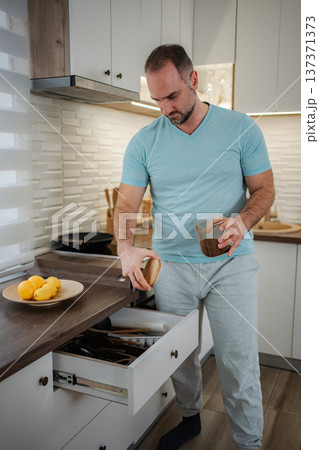 Man making morning coffee routine in modern kitchen Man making morning coffee routine in modern kitchen 137371373