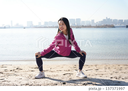 海辺で体操をする若い女性 137371997