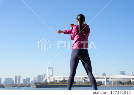 海辺で体操をする若い女性 海辺で体操をする若い女性 137372016