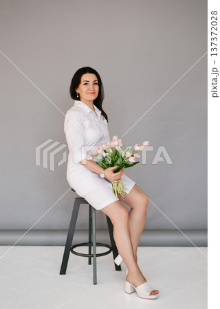Beautiful Professional Female Doctor Holding Pink Tulips Beautiful Professional Female Doctor Holding Pink Tulips 137372028