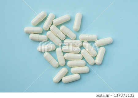 White medicine pills capsule on blue background White medicine pills capsule on blue background 137373132