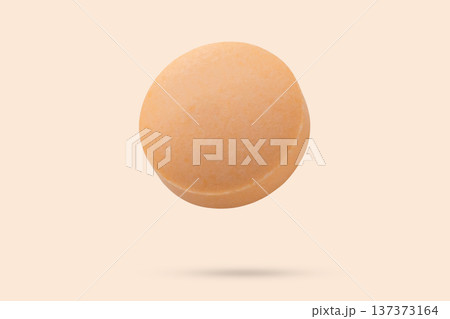 Orange medicine pill tablet flying on orange background Orange medicine pill tablet flying on orange background 137373164