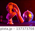 Classical white sculpture bust with robotic hand illuminated by vibrant orange and purple neon lighting 137373708