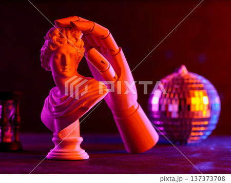 Classical white sculpture bust with robotic hand illuminated by vibrant orange and purple neon lighting 137373708